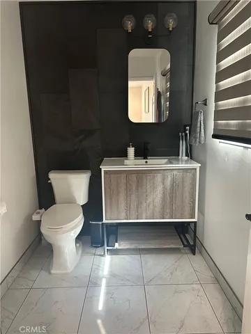 a bathroom with a toilet a sink and mirror