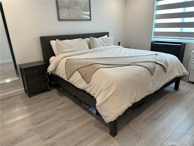 a large bed sitting in a bedroom next to a lamp