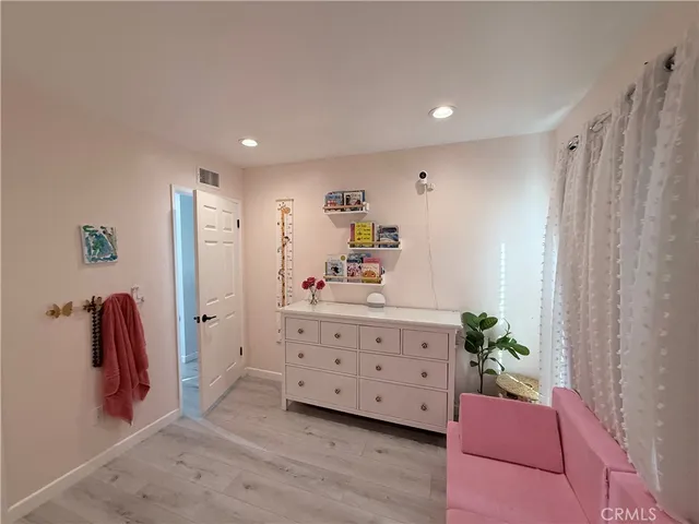a spacious bedroom with a bed and a dresser