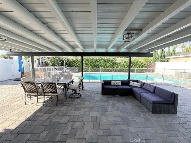 a living room with patio furniture and a floor to ceiling window