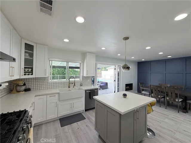 a view of a kitchen counter top space a sink wooden floor and windows