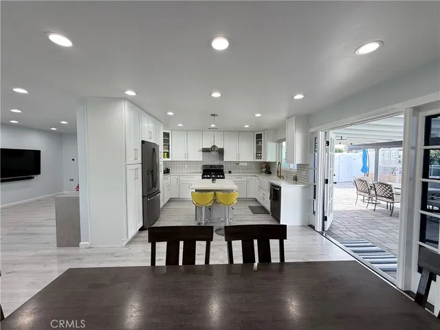 a view of kitchen with kitchen island a sink stainless steel appliances and dining table