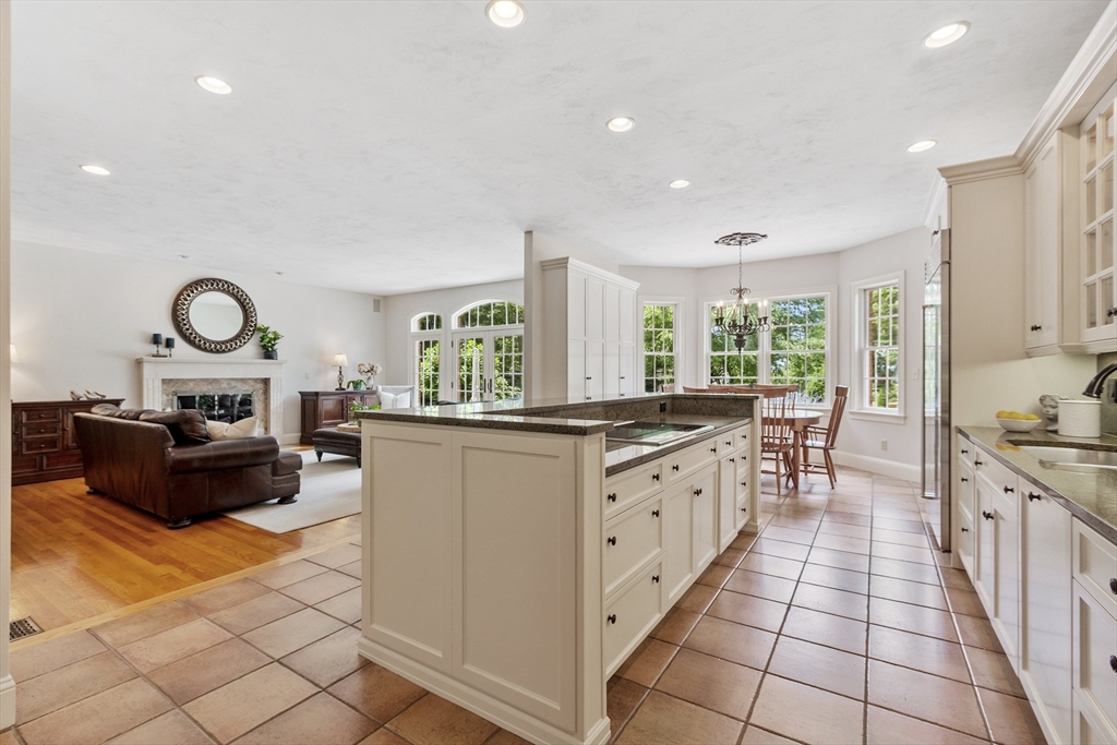 98 Fox Run Road Bolton, MA 01740 - Photo 6 of 42 a kitchen with granite countertop cabinets a stove a sink a dining table and chairs