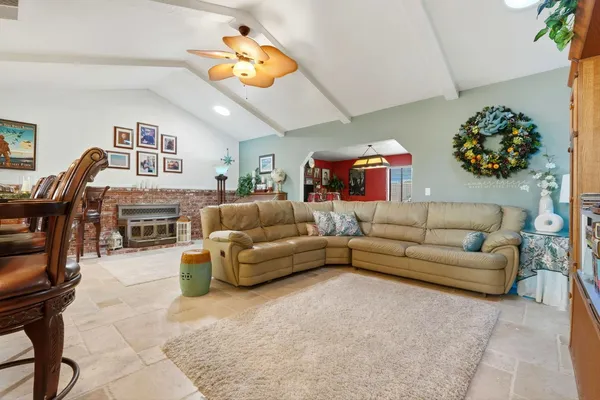 a living room with furniture a flat screen tv and a large window