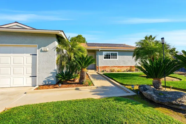 front view of house with a yard and potted plants