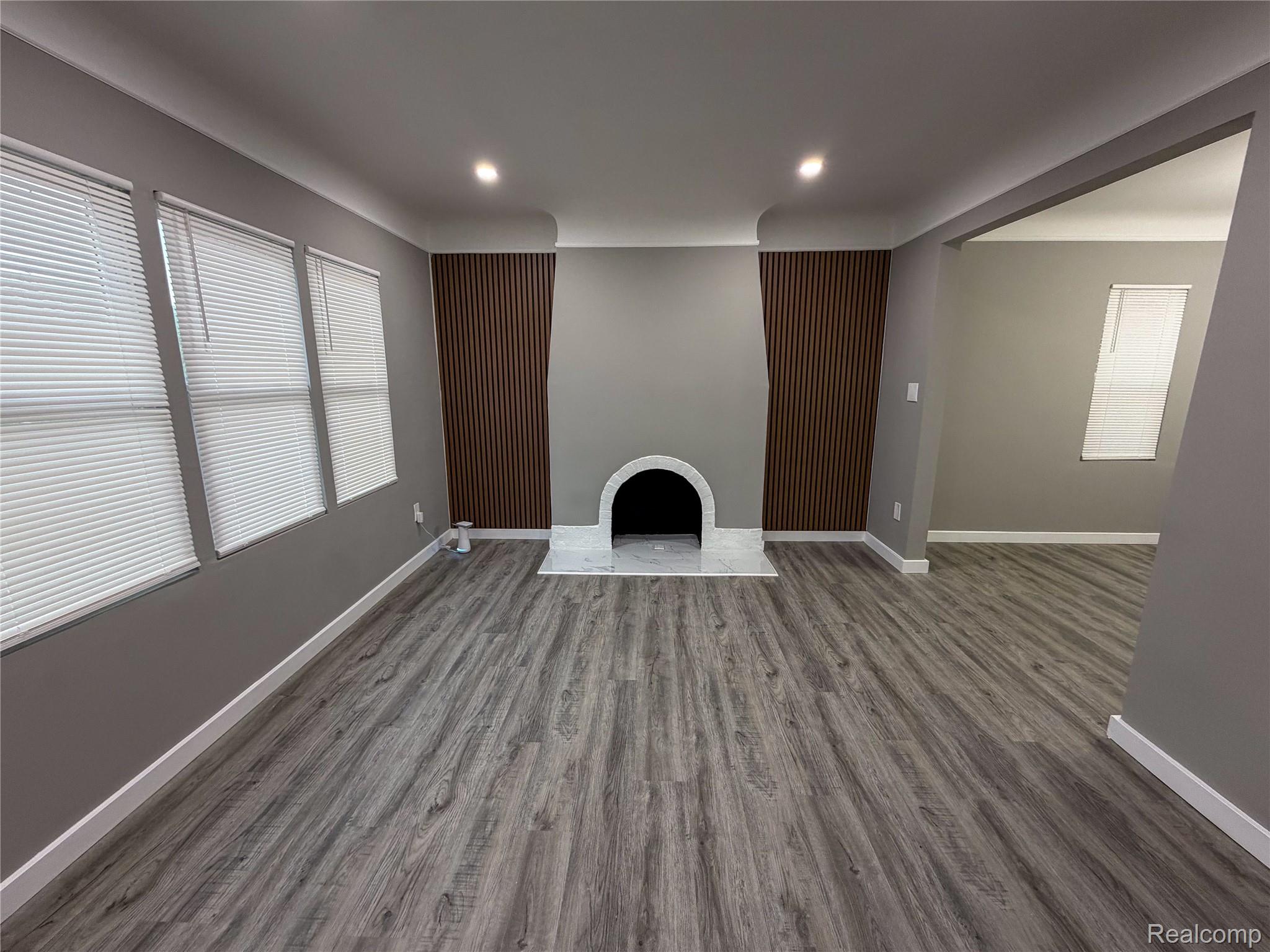 18217 Prairie Street Detroit, MI 48221 - Photo 3 of 34 Spacious interior room featuring wood-finish flooring, a decorative fireplace with a light-toned hearth and surround, and recessed ceiling lighting