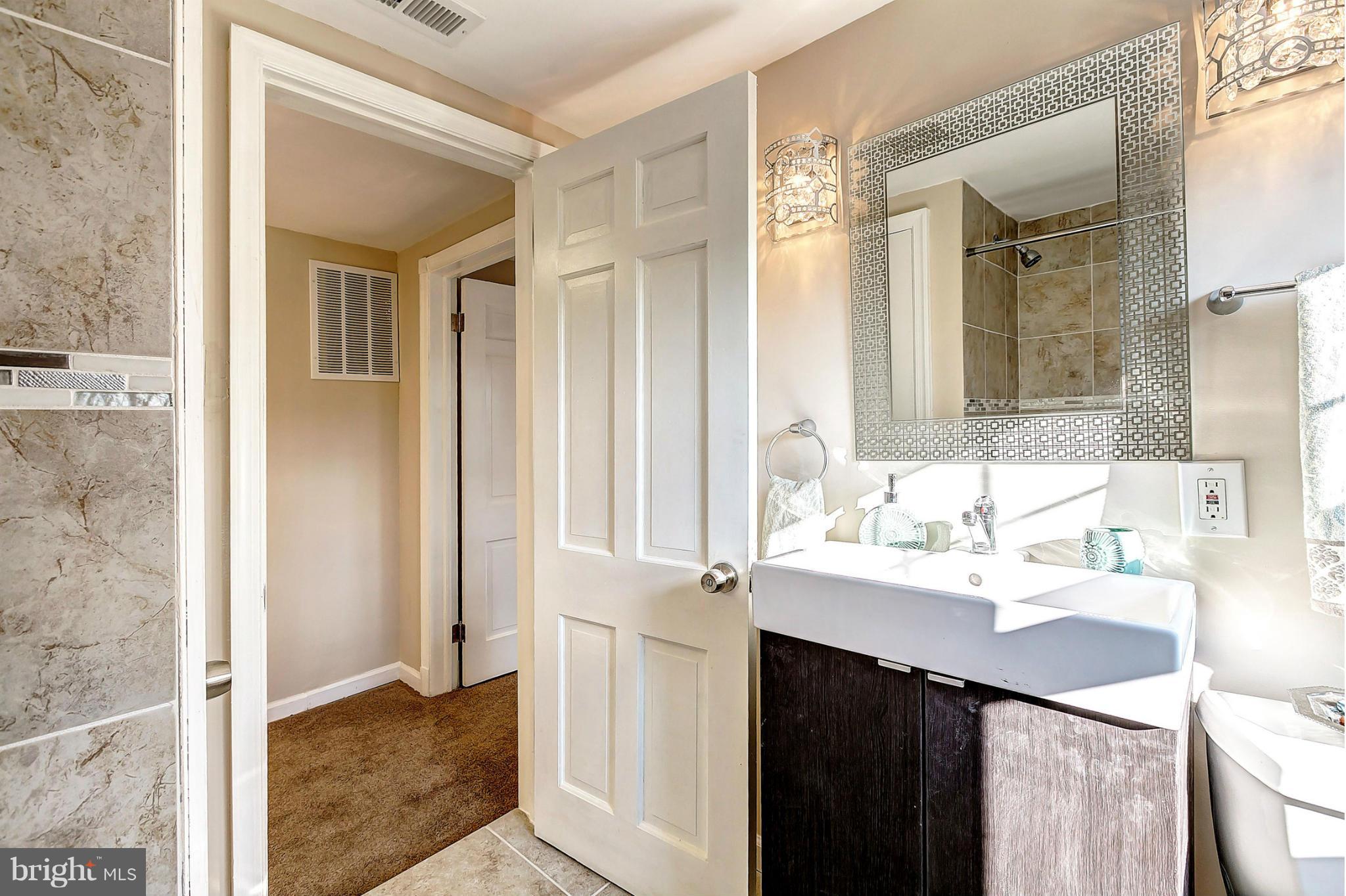 3023 Ridge Road Baltimore, MD 21244 - Photo 18 of 30 a bathroom with a sink vanity and a mirror