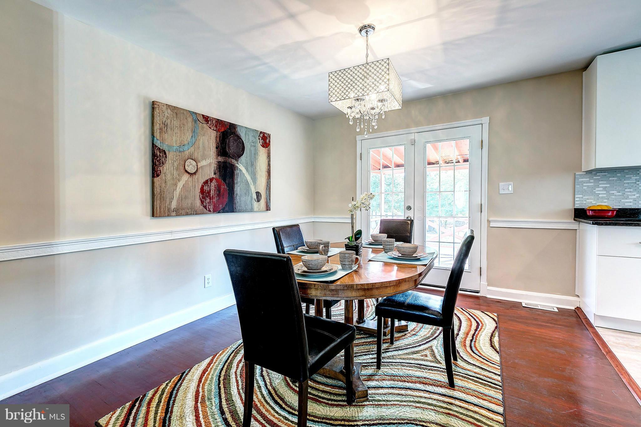 3023 Ridge Road Baltimore, MD 21244 - Photo 6 of 30 a view of a dining room with furniture a chandelier and wooden floor
