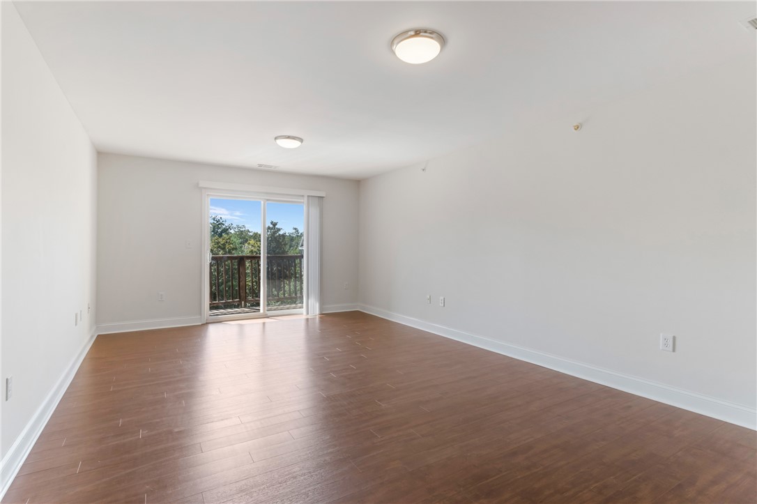 Warm wood flooring grounds this airy living space opening directly to a private back deck.