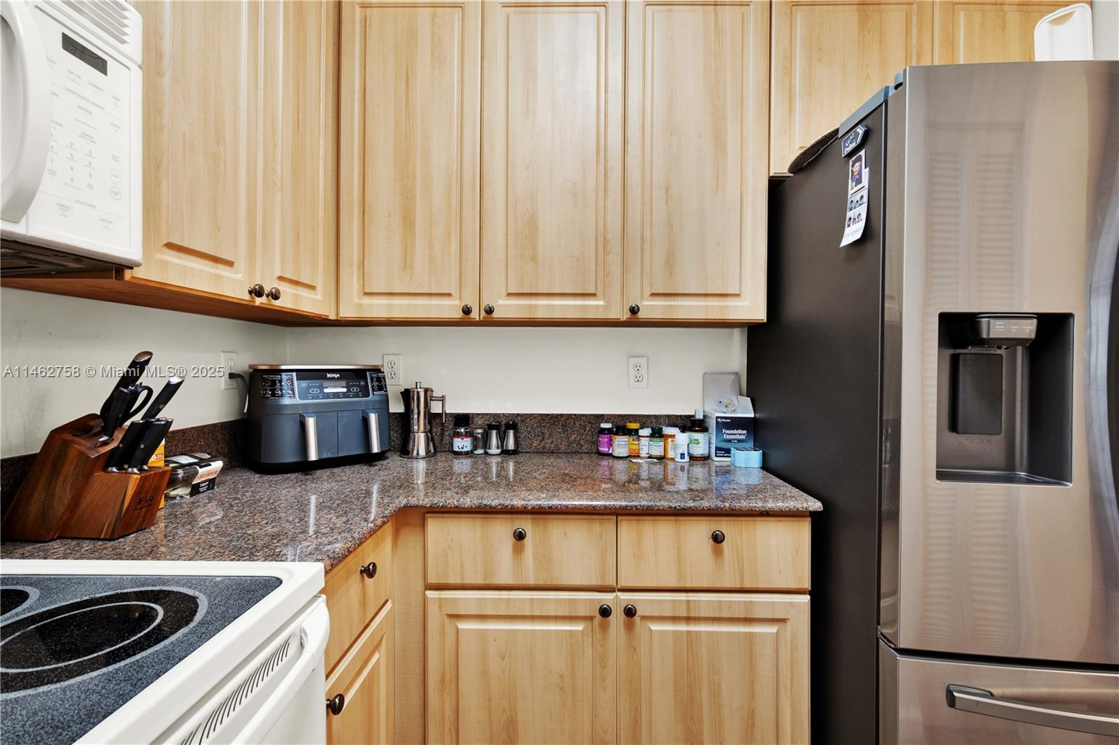 1 Century Lane, Unit 209 Miami Beach, FL 33139 - Photo 22 of 66 a kitchen with stainless steel appliances granite countertop a refrigerator sink and stove