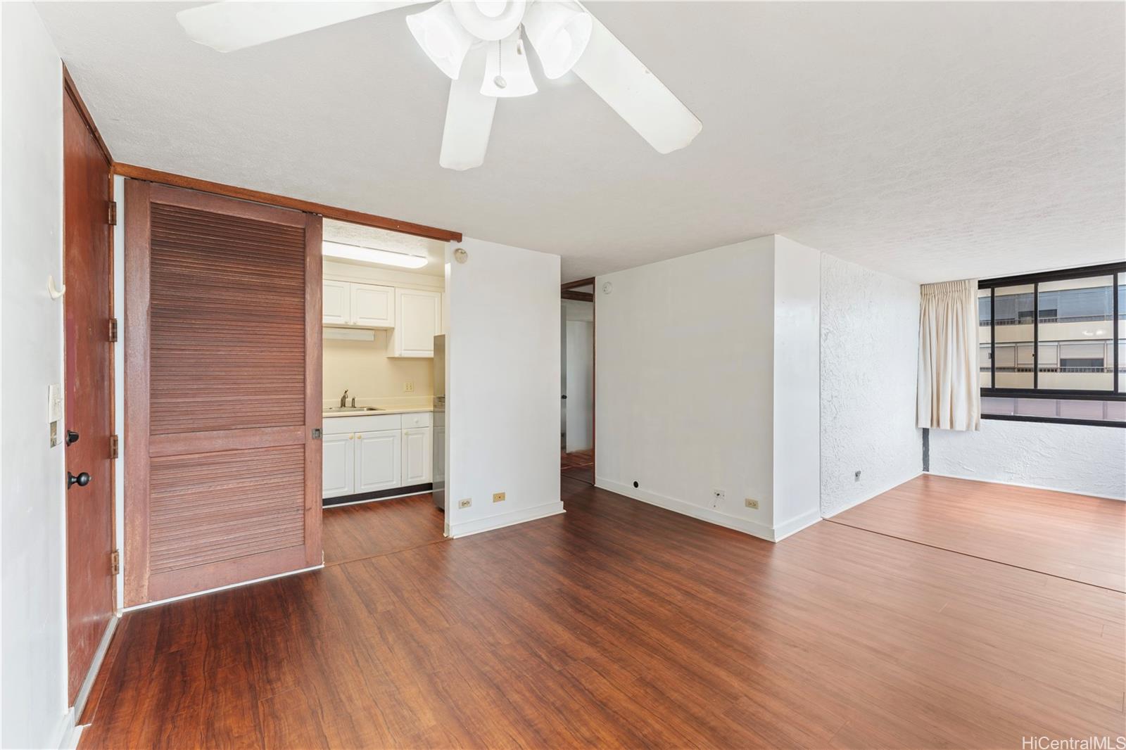 1505 Alexander Street, Unit 1205 Honolulu, HI 96822 - Photo 3 of 25 an empty room with wooden floor chandelier and windows