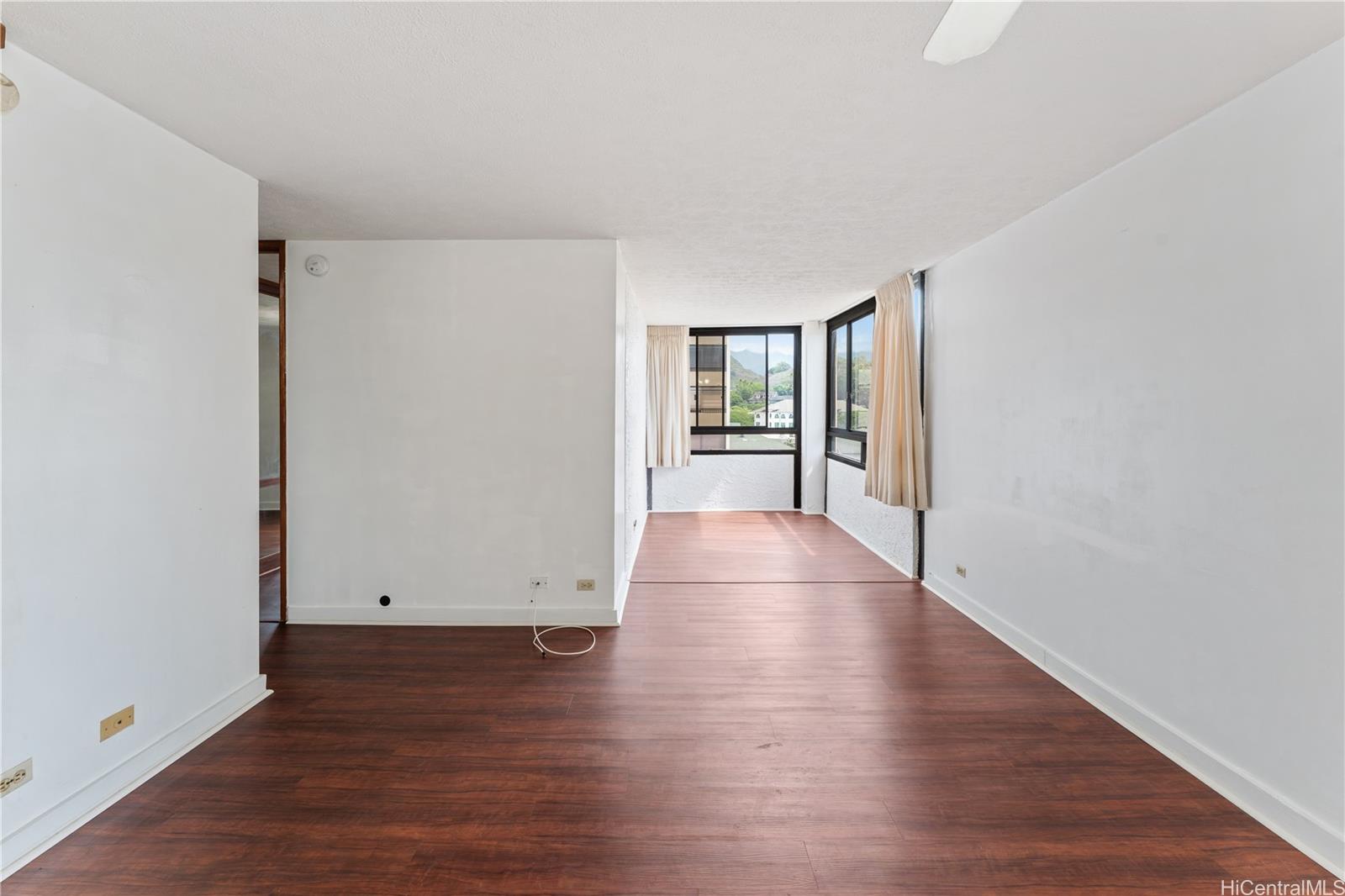 1505 Alexander Street, Unit 1205 Honolulu, HI 96822 - Photo 5 of 25 an empty room with wooden floor and windows