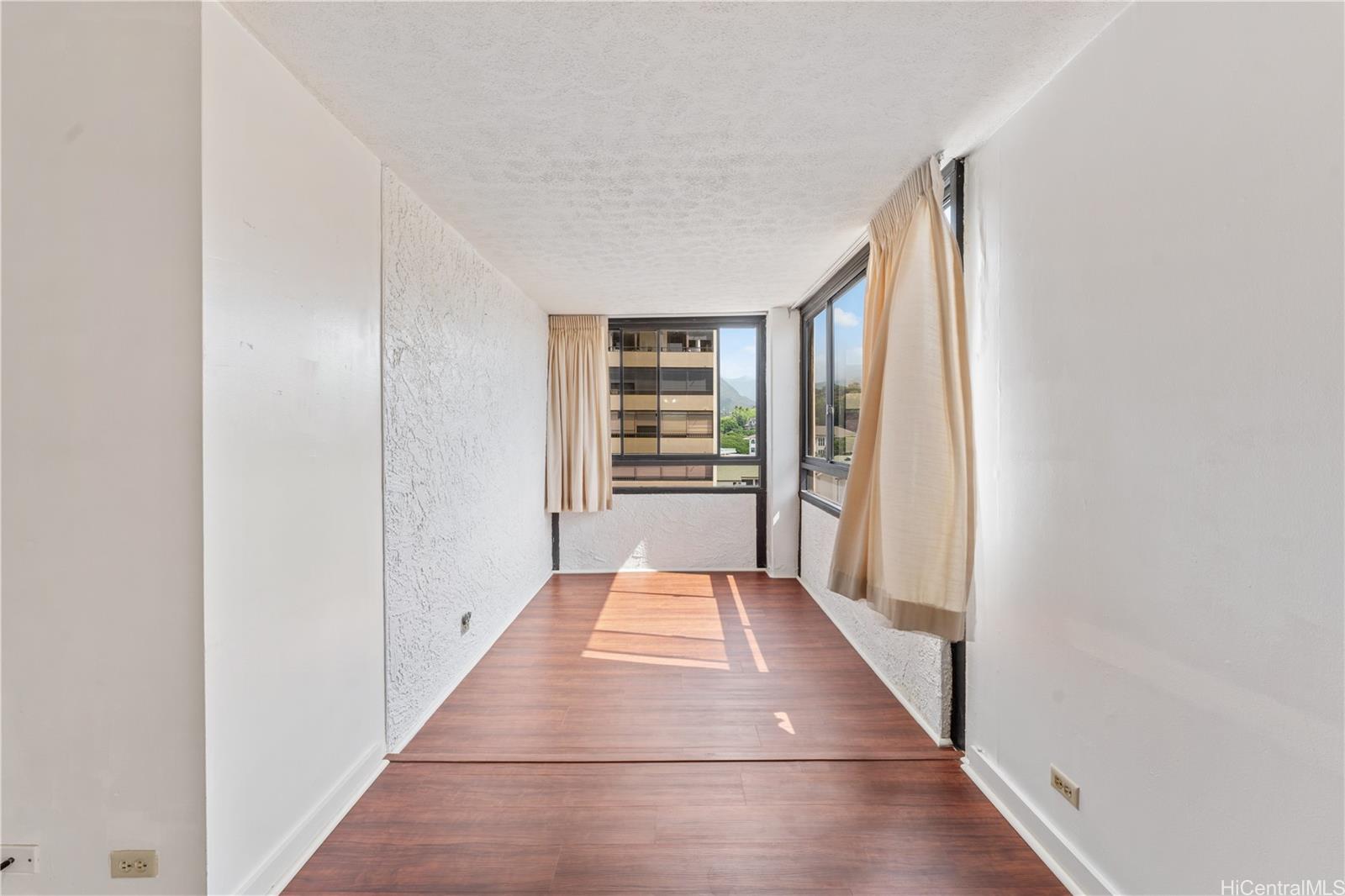 1505 Alexander Street, Unit 1205 Honolulu, HI 96822 - Photo 7 of 25 a view of a hallway with wooden floor and staircase