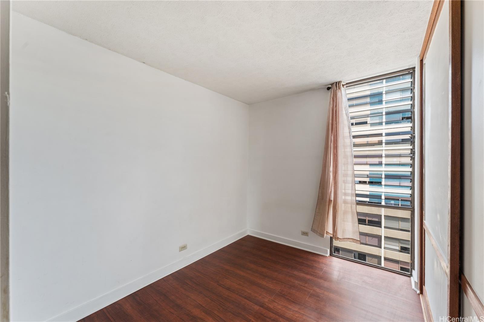 1505 Alexander Street, Unit 1205 Honolulu, HI 96822 - Photo 10 of 25 a view of an empty room with a window and wooden floor