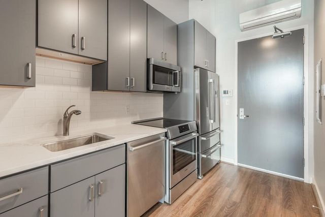 a kitchen with stainless steel appliances a sink stove and refrigerator