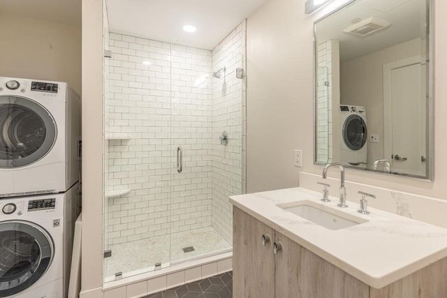 a bathroom with a sink vanity mirror and shower