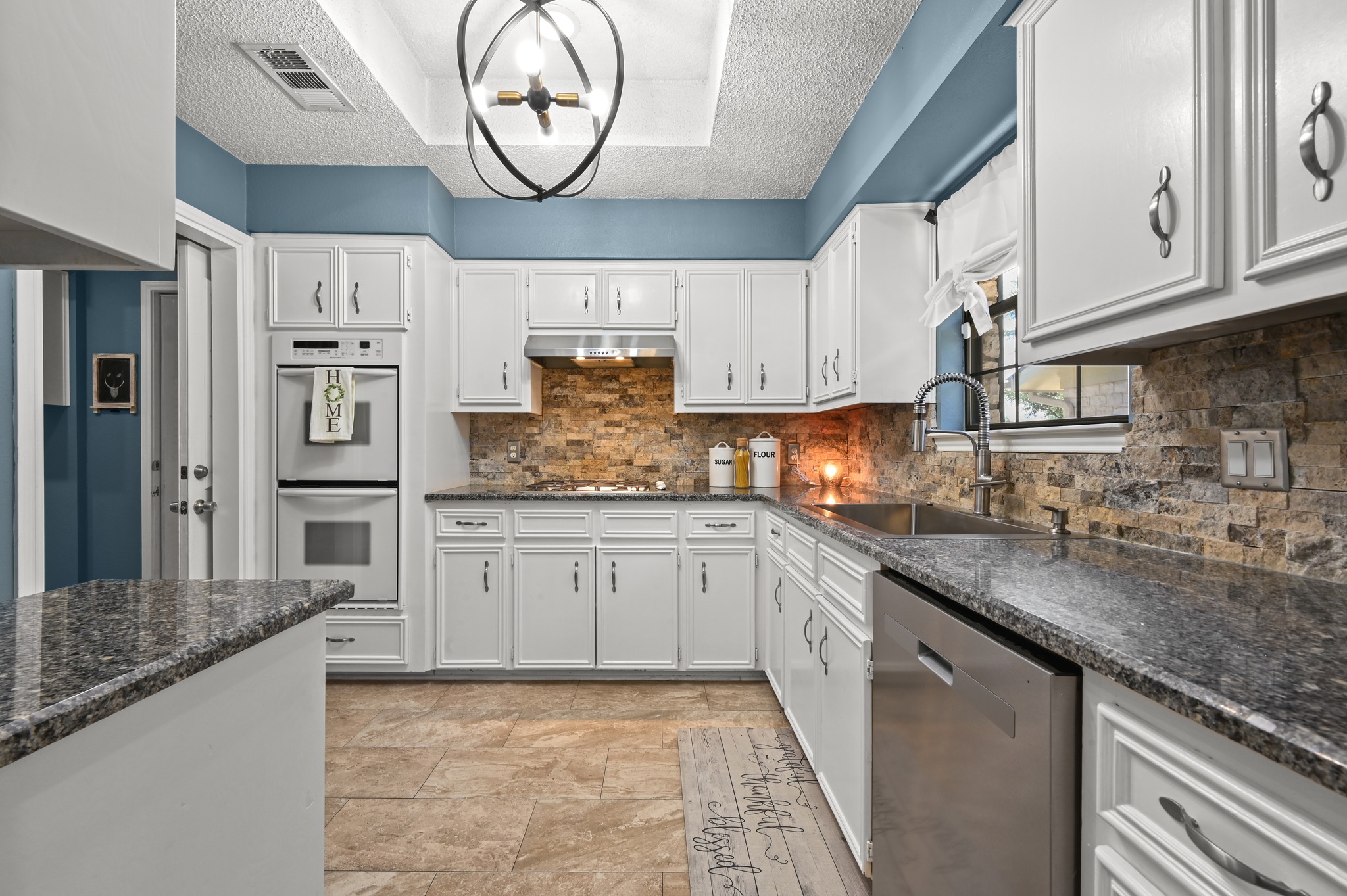 303 Pin Oak Drive Georgetown, TX 78628 - Photo 13 of 36 a kitchen with stainless steel appliances granite countertop a sink and cabinets