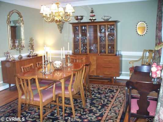 3021 East Brigstock Road Midlothian, VA 23113 - Photo 3 of 12 a view of a dining room with furniture a chandelier and wooden floor
