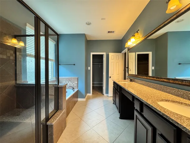 a large bathroom with a large tub and sink