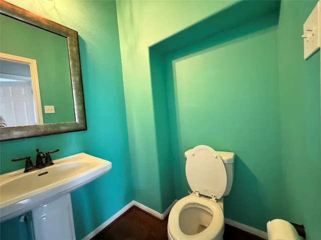 a bathroom with a toilet mirror and vanity