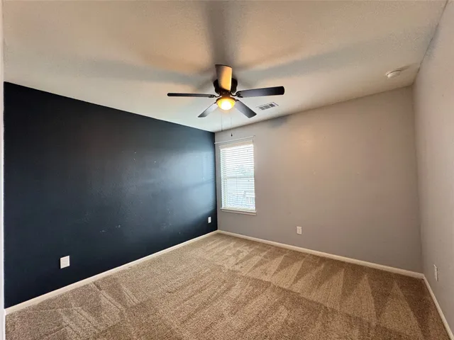 a view of a room with a ceiling fan and window