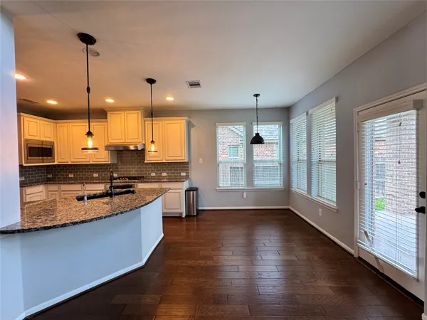 a large kitchen with stainless steel appliances a large counter top a stove a chimney a sink and a large window