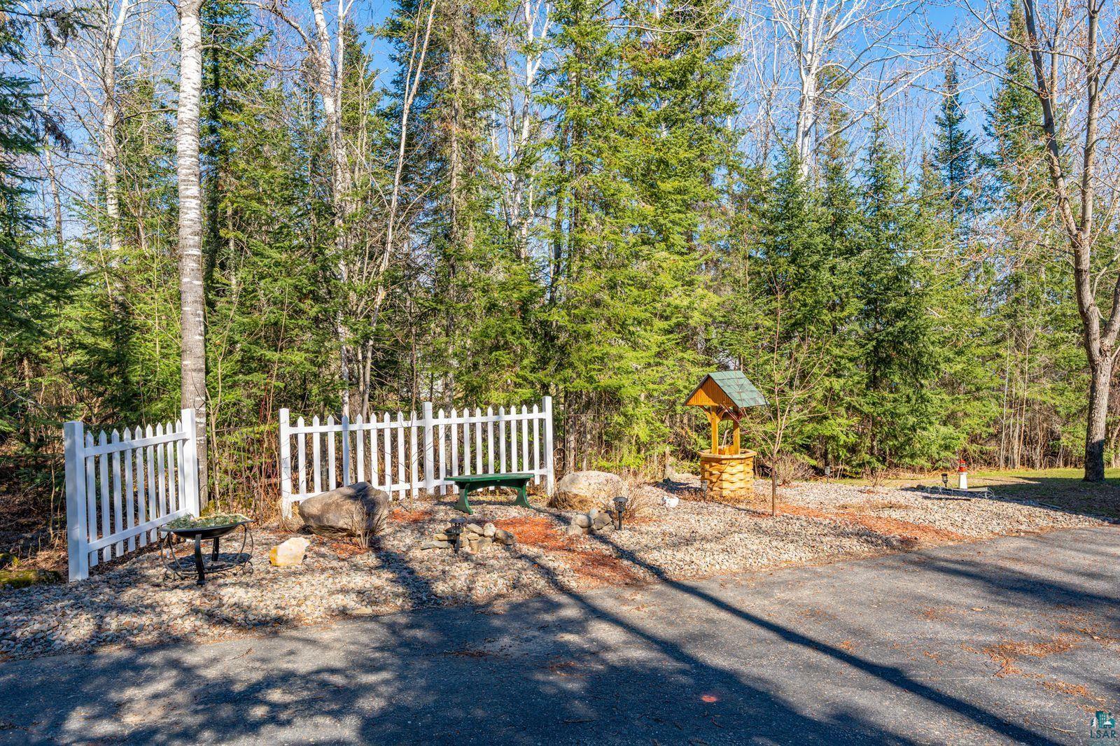4452 Moccasin Point Road Tower, MN 55790 - Photo 30 of 44 Picket fence entry with a decorative wishing well and mature trees