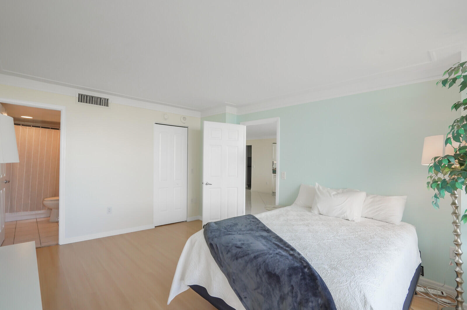 5600 North Flagler Drive, Unit 907 West Palm Beach, FL 33407 - Photo 15 of 48 a bedroom with a bed and a potted plant