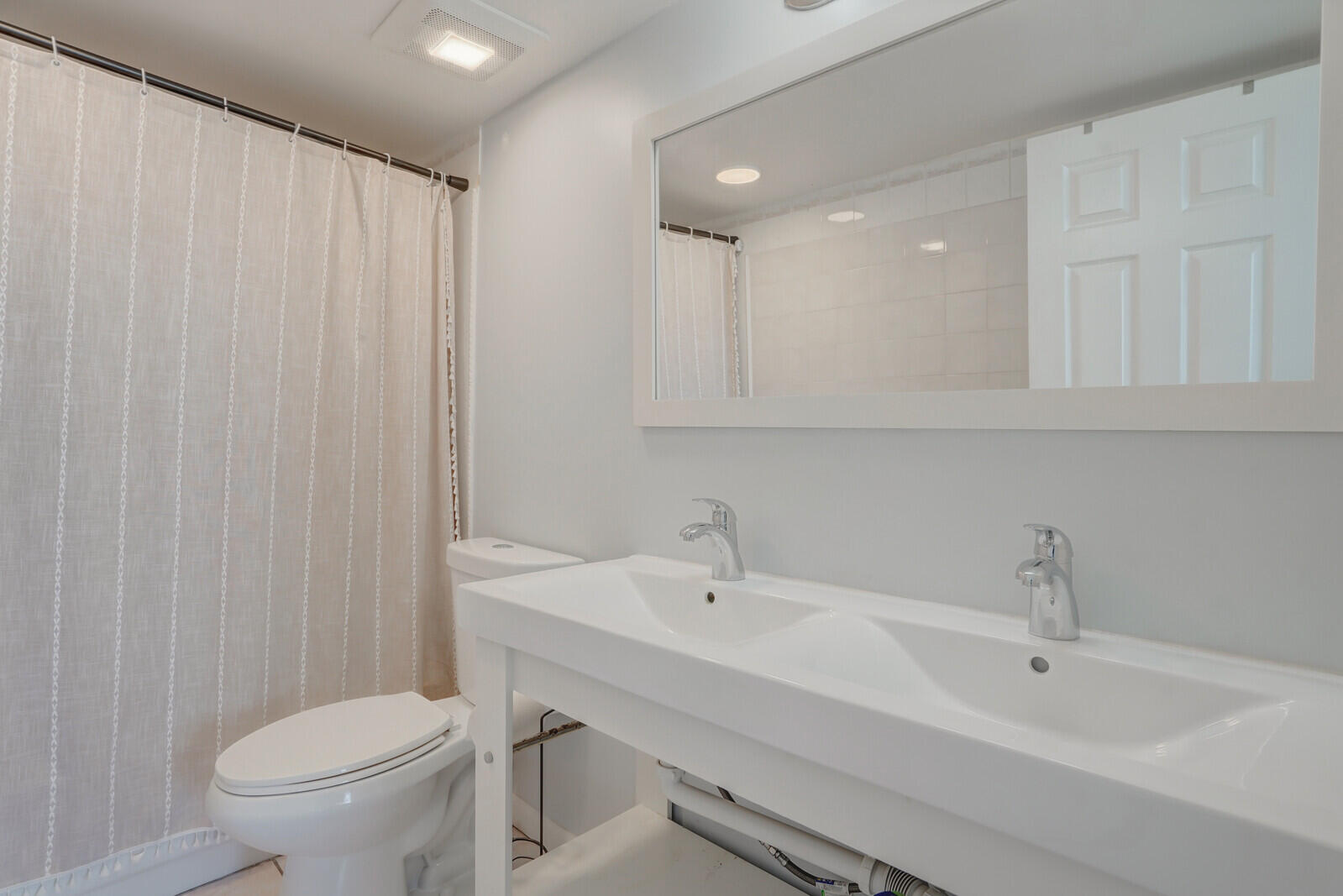5600 North Flagler Drive, Unit 907 West Palm Beach, FL 33407 - Photo 16 of 48 a bathroom with a sink a toilet and a mirror