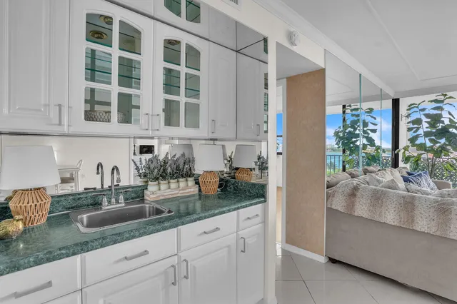 a kitchen with granite countertop white cabinets and window