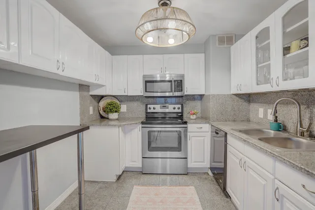 a kitchen with stainless steel appliances granite countertop a sink and cabinets
