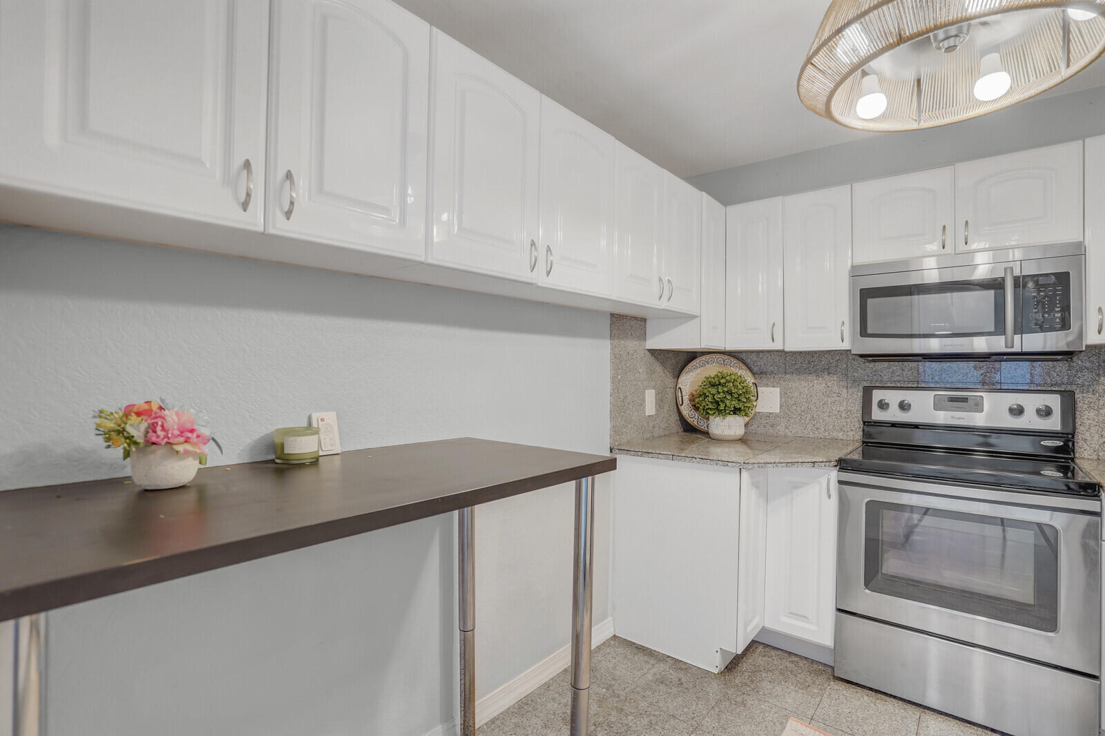 5600 North Flagler Drive, Unit 907 West Palm Beach, FL 33407 - Photo 5 of 48 a kitchen with stainless steel appliances granite countertop a sink dishwasher and cabinets with wooden floor