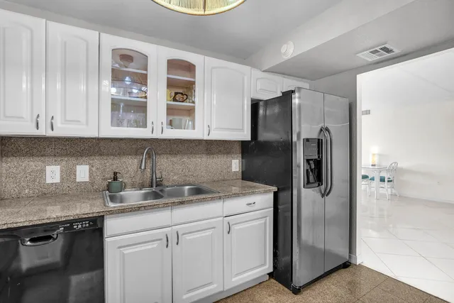 a kitchen with stainless steel appliances granite countertop a refrigerator and a sink