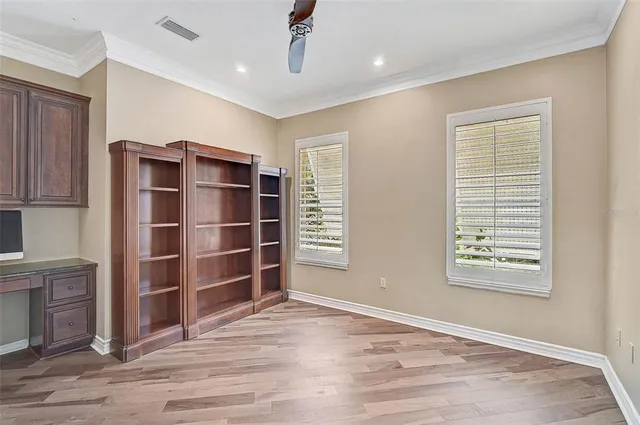a view of an empty room with a window and wooden shelves