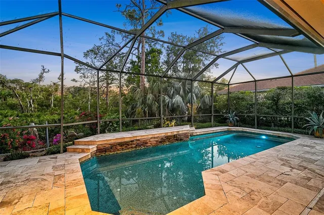 a view of a backyard with swimming pool and sitting area