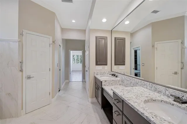 an empty room with wooden floor chandelier fan and windows