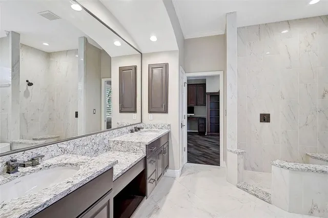 a spacious bathroom with a granite countertop sink and a mirror