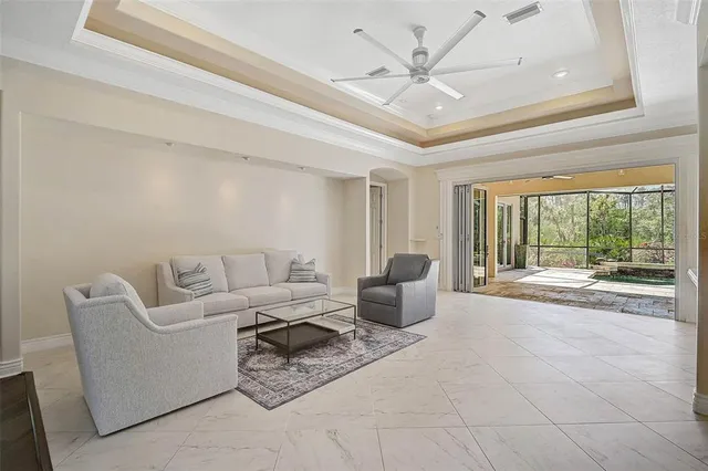 a living room with furniture a chandelier and a large window