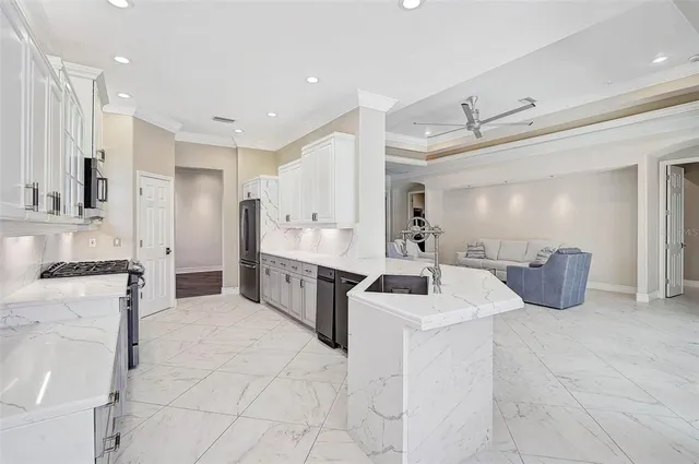 a large white kitchen with granite countertop a sink a stove a washer and dryer