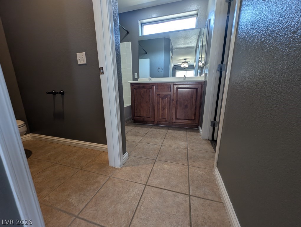9121 Spoonbill Ridge Place Las Vegas, NV 89143 - Photo 14 of 26 Step into a well-lit bathroom featuring a dual vanity and tile flooring.