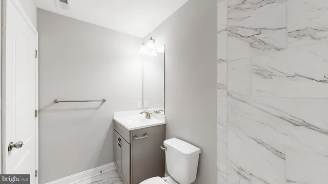 a kitchen with granite countertop kitchen island stainless steel appliances a sink refrigerator and white cabinets