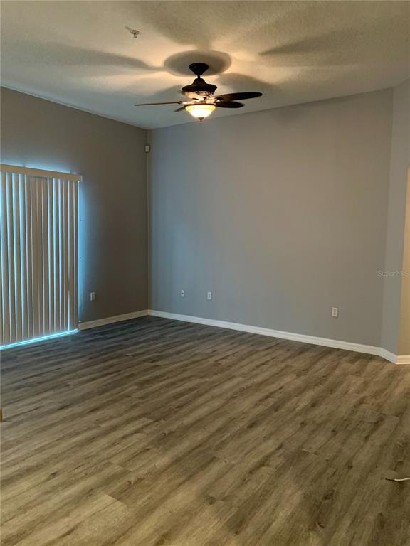 7131 Harmony Square Drive South, Unit 3 Harmony, FL 34773 - Photo 11 of 16 wooden floor in an empty room with a window