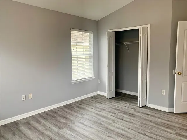 an empty room with wooden floor and closet