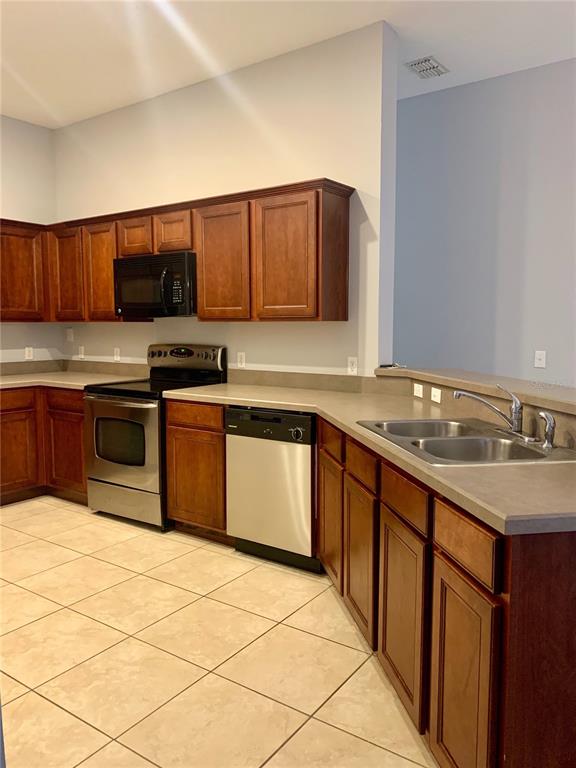7131 Harmony Square Drive South, Unit 3 Harmony, FL 34773 - Photo 7 of 16 a kitchen with stainless steel appliances granite countertop a sink stove and refrigerator