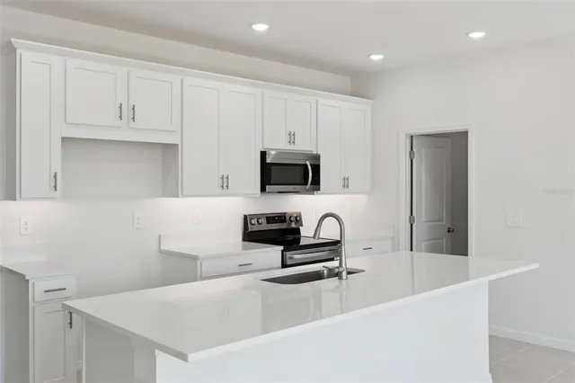 a kitchen with granite countertop a sink a stove and microwave