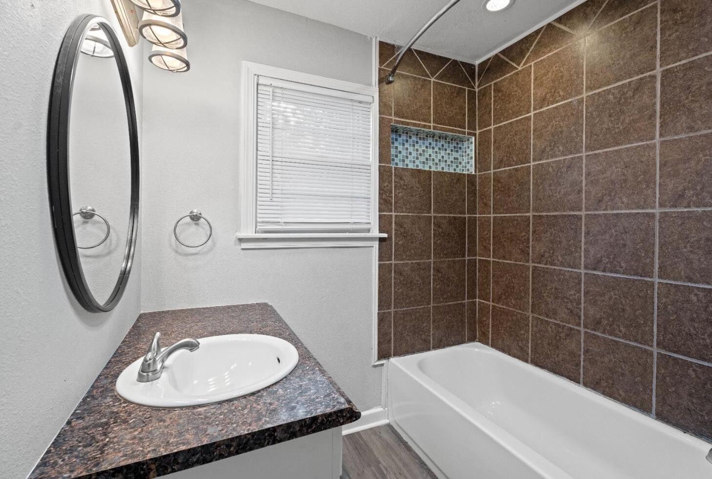 5105 38th Street Lubbock, TX 79414 - Photo 7 of 13 a bathroom with a granite countertop sink and a mirror
