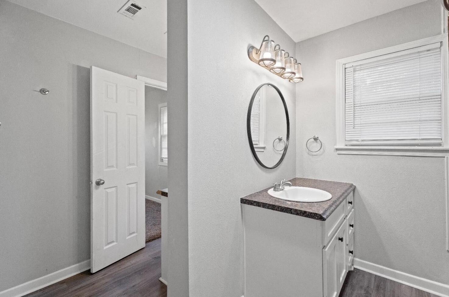 5105 38th Street Lubbock, TX 79414 - Photo 8 of 13 a bathroom with a granite countertop sink and a mirror