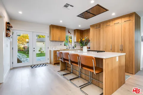 a dining hall with stainless steel appliances granite countertop a stove and a refrigerator
