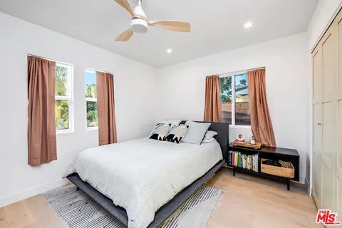 a bedroom with a bed and a large window