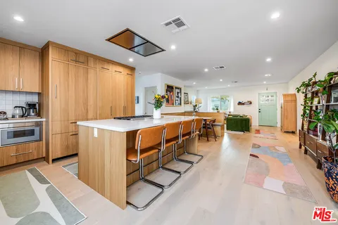 a kitchen with stainless steel appliances kitchen island granite countertop a refrigerator and a stove top oven